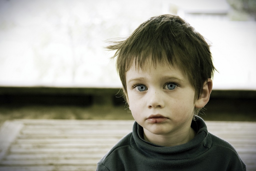 Lonely child sits by himself.